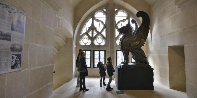 Kind steht vor einer Flügellöwen-Statue im Schloss Pierrefonds in Nordfrankreich. Copyright: CRTC Hauts-de-France - Nicolas Bryant