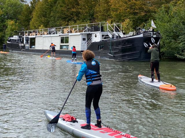 Gruppe paddelt vorbei an einem Boot auf der Deûle in Lille, Nordfrankreich. Copyright: le Grand Huit Jb Degandt