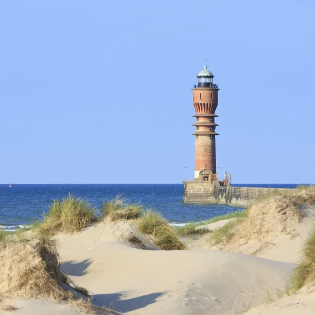 Dunkerque. Le phare Saint Pol au bout de la digue du Break derriere les oyats et les dunes du Break.